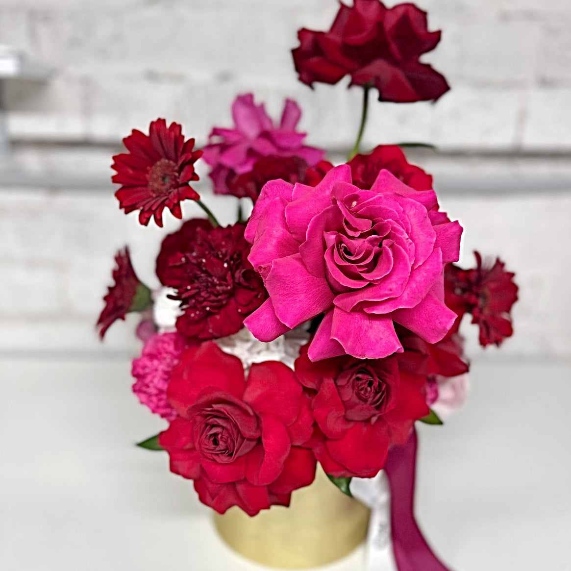 Premium red and hot pink rose arrangement in a brass gold vase Valentine's Day flowers Sydney