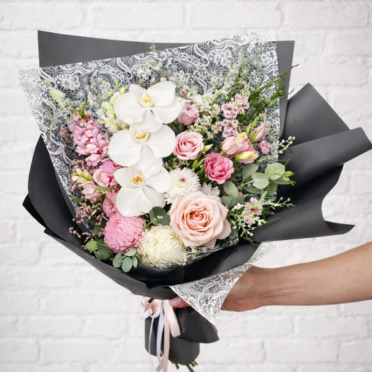 Bouquet of premium white orchids paired with blush roses and delicate seasonal blooms, this arrangement blends timeless beauty with modern luxury. Flower deliver across North Shore and Parramatta.