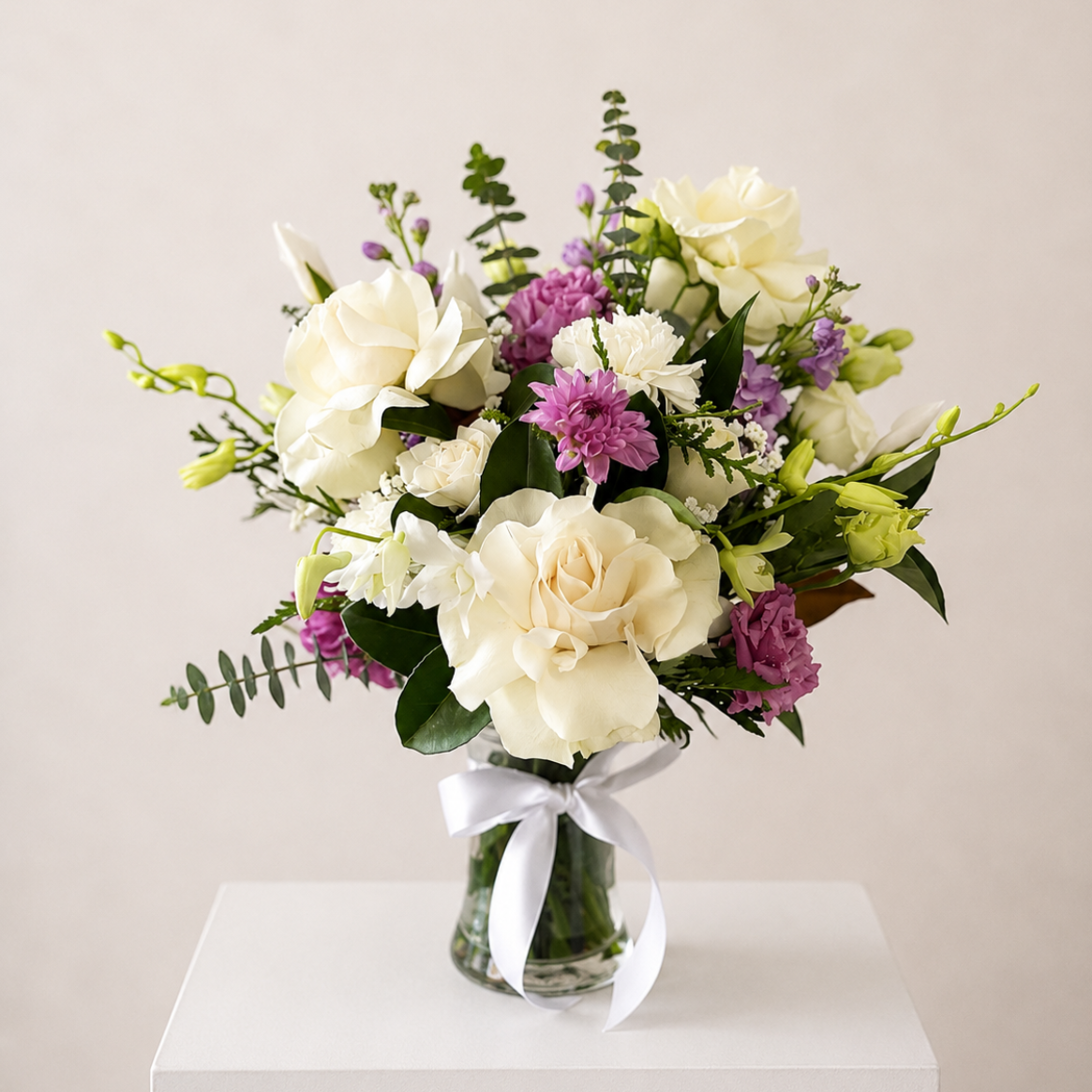 Elegant white roses with mauve highlights, seasonal blooms and lush foliage arranged in a glass vase. Perfect for birthdays, sympathy, thank you and special occasions. Same day Sydney flower delivery available.