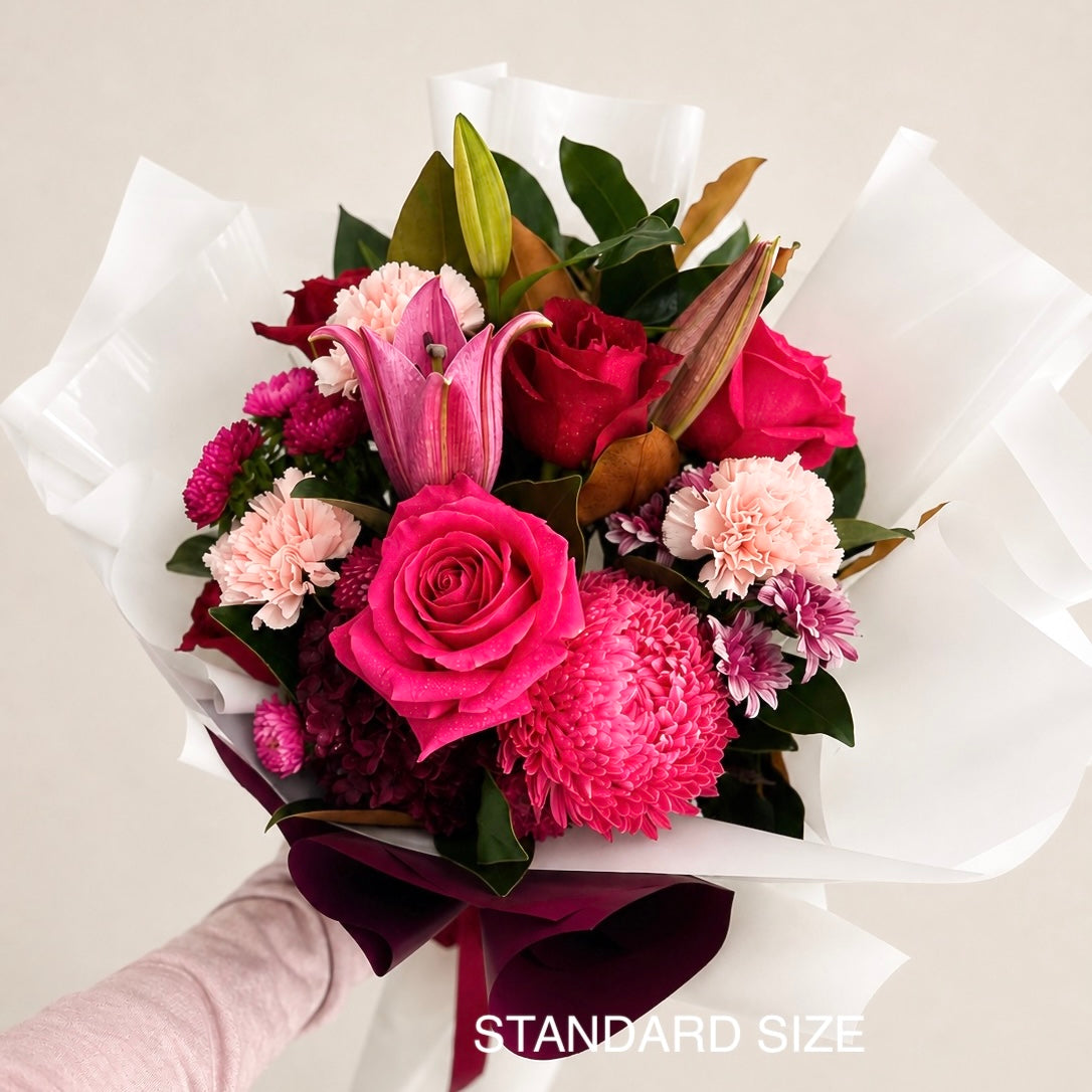 A mix of bright pink, deep red, and magenta roses and seasonal flowers available for same-day flower delivery Sydney wide 
